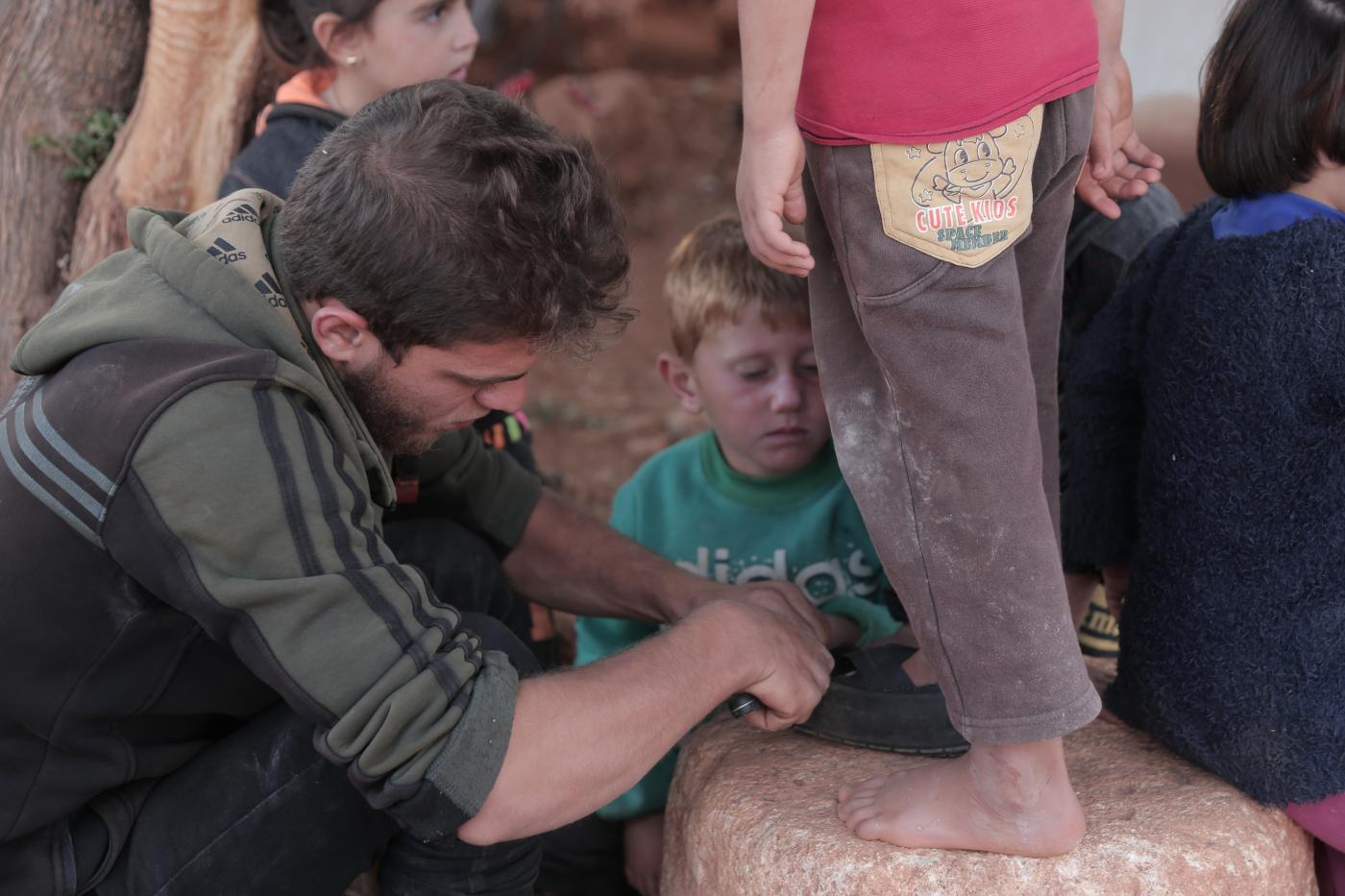 بالصور: رجل سوري يصنع أحذية من الإطارات للأطفال النازحين